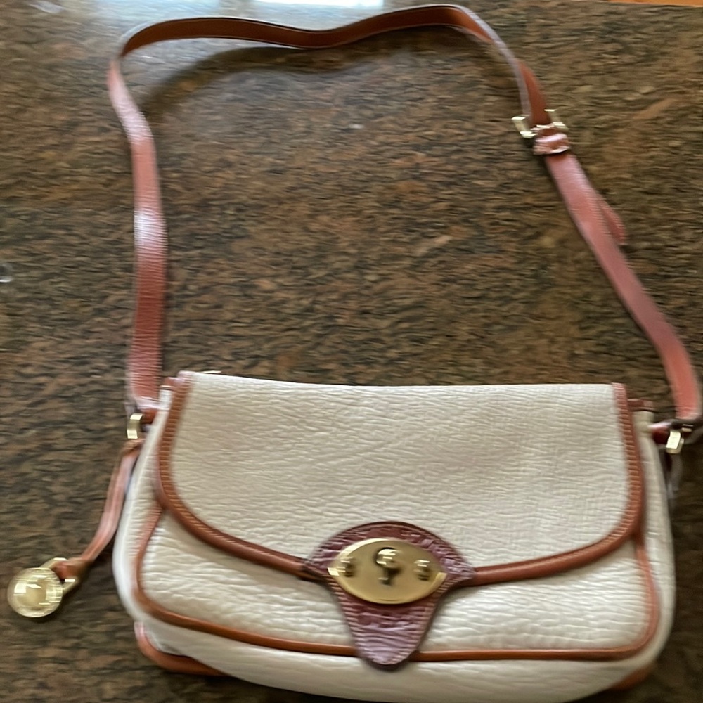 Dooney and Bourke shoulder bag. Off white with saddle brown trimming.